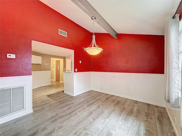 7119 Lenape Cir, New Port Richey, FL 34653 - unfurnished dining area with beam ceiling, wood finished floors, a wainscoted wall, and high vaulted ceiling