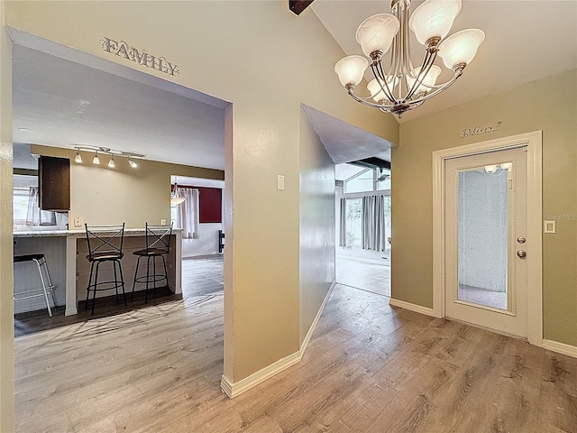 7119 Lenape Cir, New Port Richey, FL 34653 - dining room with wood finished floors, baseboards, a chandelier, and vaulted ceiling