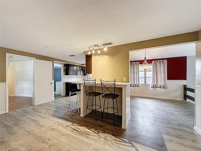 7119 Lenape Cir, New Port Richey, FL 34653 - kitchen with light countertops, light wood-style floors, a breakfast bar, and open floor plan