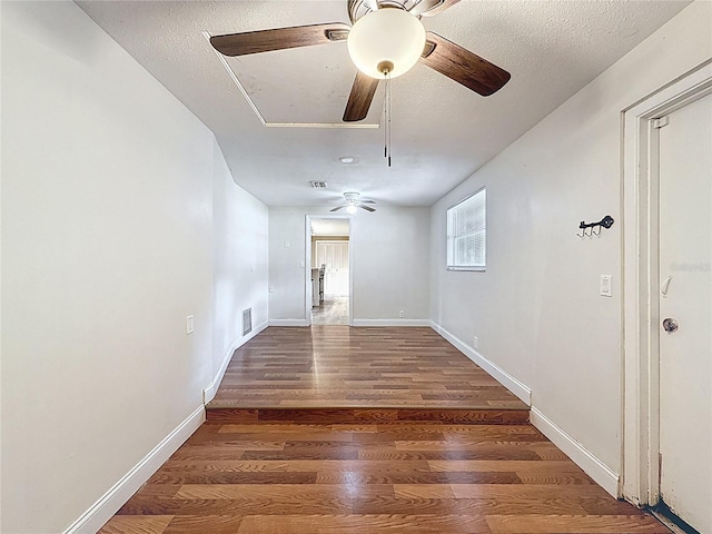 7119 Lenape Cir, New Port Richey, FL 34653 - unfurnished room with attic access, a ceiling fan, wood finished floors, a textured ceiling, and baseboards