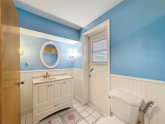 7119 Lenape Cir, New Port Richey, FL 34653 - bathroom featuring wainscoting, tile patterned floors, vanity, and toilet