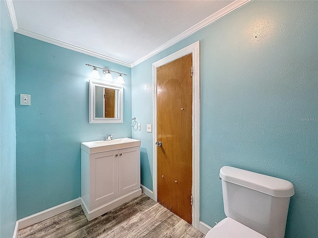 7119 Lenape Cir, New Port Richey, FL 34653 - bathroom featuring ornamental molding, vanity, wood finished floors, toilet, and baseboards