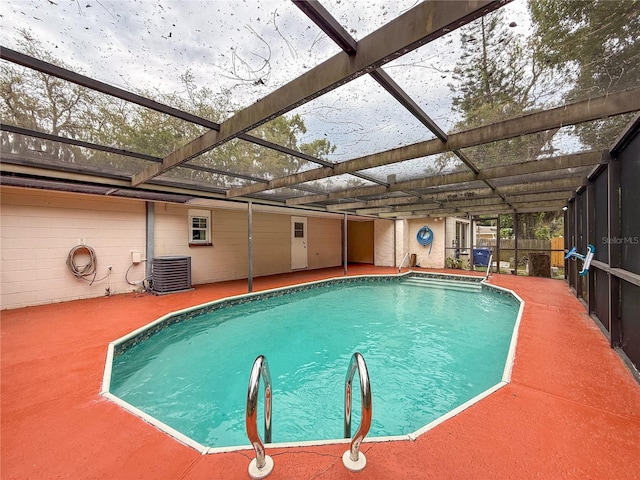 7119 Lenape Cir, New Port Richey, FL 34653 - outdoor pool featuring central AC unit and glass enclosure