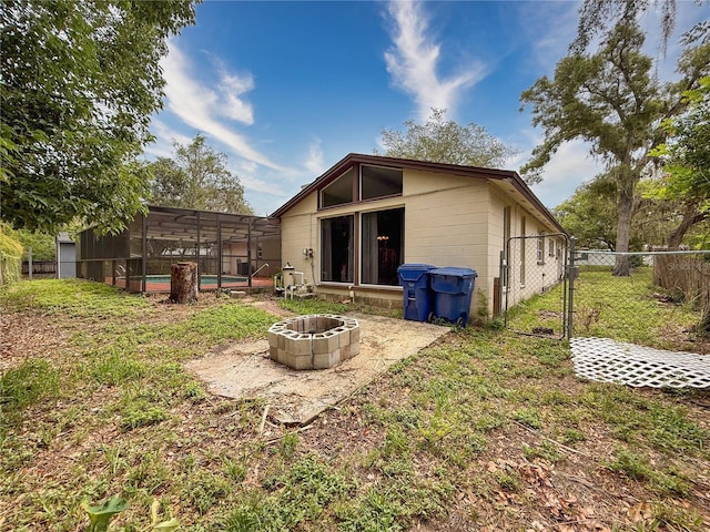 7119 Lenape Cir, New Port Richey, FL 34653 - rear view of property featuring an outdoor fire pit, glass enclosure, and a patio