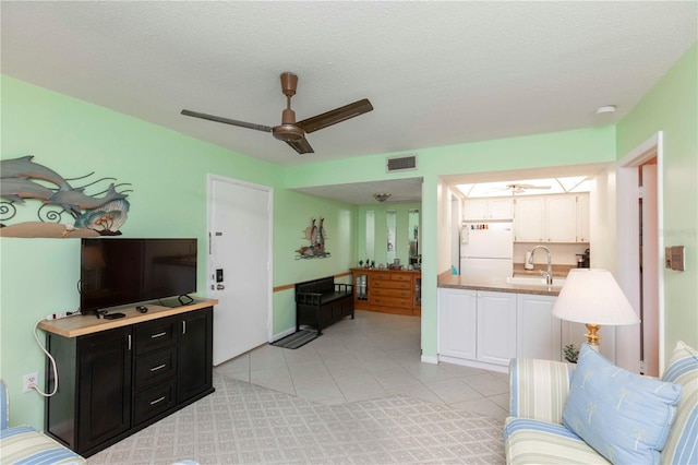 5123 Topaz Ln Unit 206, New Port Richey, FL 34652 - living room featuring ceiling fan, light tile patterned floors, and a textured ceiling