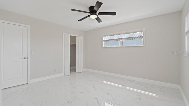 1024 Spindle Palm Way, Apollo Beach, FL 33572 - unfurnished bedroom featuring light marble finish flooring, baseboards, a closet, and a ceiling fan
