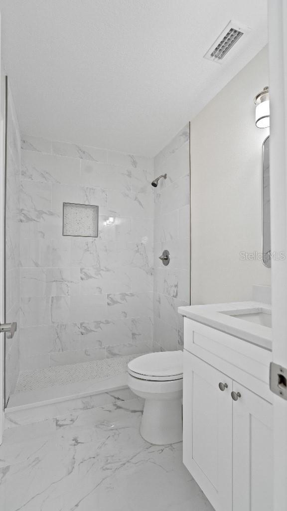 1024 Spindle Palm Way, Apollo Beach, FL 33572 - full bathroom featuring vanity, marble finish floors, toilet, and a shower stall