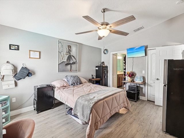 10120 Ives Loop, Hudson, FL 34667 - bedroom with freestanding refrigerator, light wood-style floors, vaulted ceiling, baseboards, and ceiling fan