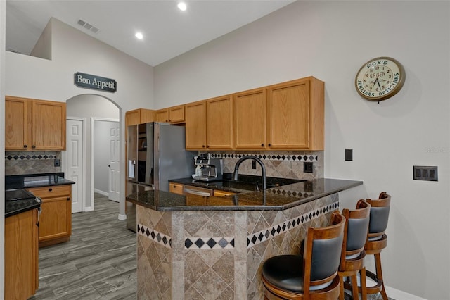 1862 Wood Bend St, Tarpon Springs, FL 34689 - kitchen featuring baseboards, arched walkways, a peninsula, backsplash, and a towering ceiling