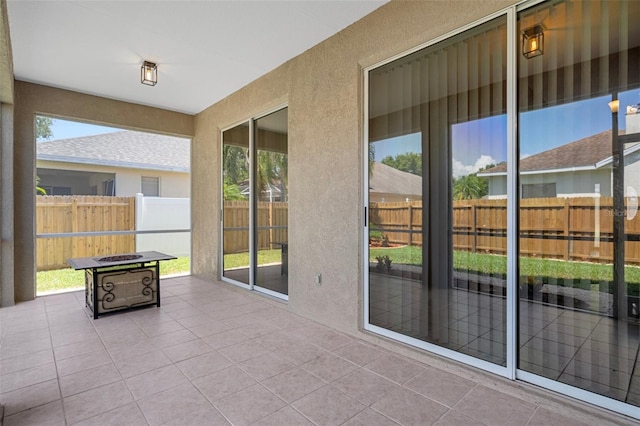 1862 Wood Bend St, Tarpon Springs, FL 34689 - unfurnished sunroom featuring tile patterned flooring, healthy amount of natural light, and a textured wall