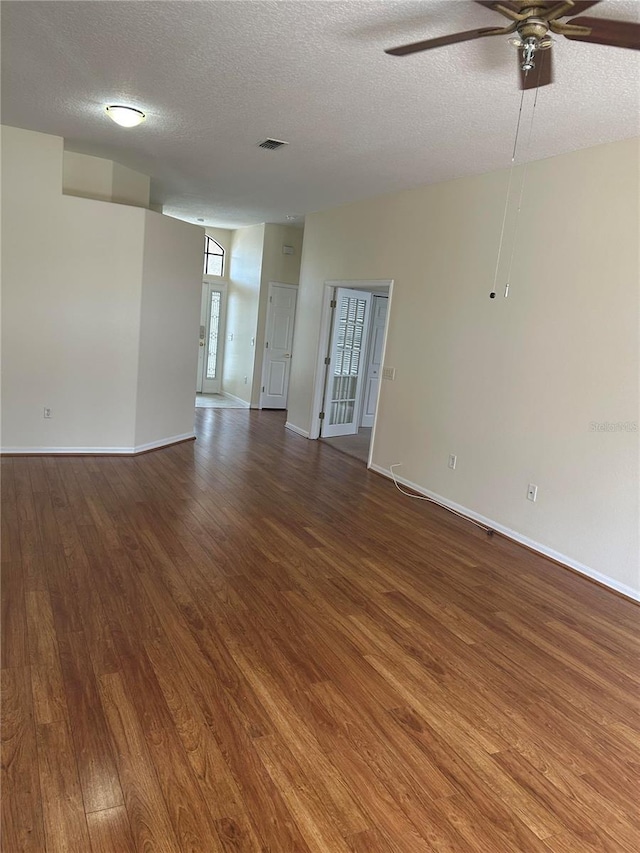 11520 Lounds Ct, New Port Richey, FL 34654 - unfurnished room with wood finished floors, a textured ceiling, a ceiling fan, and baseboards