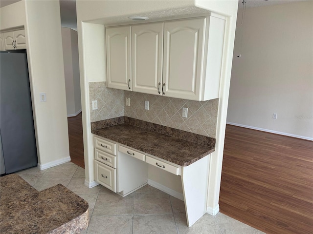 11520 Lounds Ct, New Port Richey, FL 34654 - kitchen with fridge, dark countertops, tasteful backsplash, baseboards, and light tile patterned floors