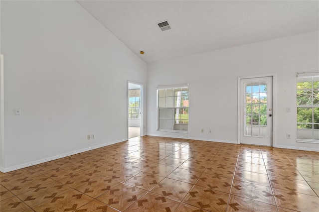 4125 Mc Clung Dr, New Port Richey, FL 34653 - empty room with healthy amount of natural light, high vaulted ceiling, light tile patterned floors, and baseboards