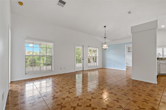 4125 Mc Clung Dr, New Port Richey, FL 34653 - spare room featuring healthy amount of natural light, light tile patterned floors, and a chandelier