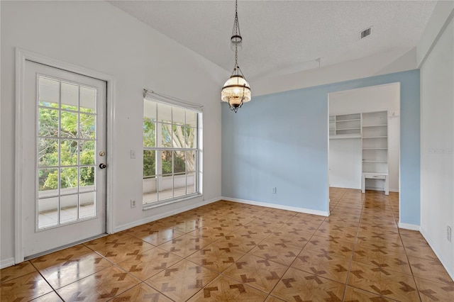 4125 Mc Clung Dr, New Port Richey, FL 34653 - unfurnished dining area with baseboards, a chandelier, a textured ceiling, and tile patterned floors