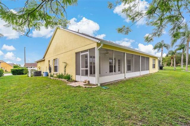 4125 Mc Clung Dr, New Port Richey, FL 34653 - back of property with a sunroom, ceiling fan, a lawn, stucco siding, and central AC unit