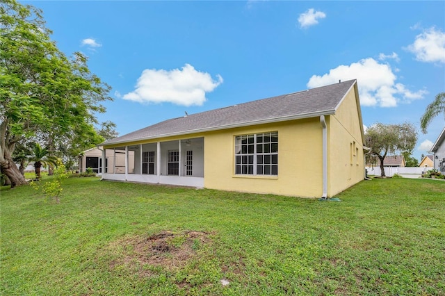 4125 Mc Clung Dr, New Port Richey, FL 34653 - rear view of house featuring stucco siding, a lawn, and a sunroom