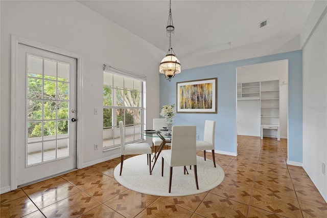 4125 Mc Clung Dr, New Port Richey, FL 34653 - tiled dining space featuring baseboards, a chandelier, and a textured ceiling