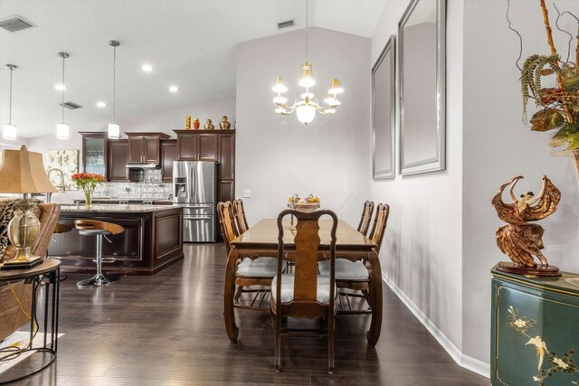 1142 Wolford Dr, Trinity, FL 34655 - dining area with vaulted ceiling, a chandelier, dark wood-style flooring, and baseboards