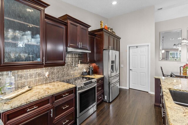 1142 Wolford Dr, Trinity, FL 34655 - kitchen with appliances with stainless steel finishes, under cabinet range hood, decorative backsplash, light stone countertops, and dark wood finished floors