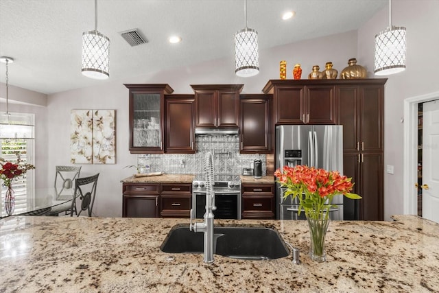 1142 Wolford Dr, Trinity, FL 34655 - kitchen featuring stainless steel appliances, lofted ceiling, decorative backsplash, light stone counters, and under cabinet range hood