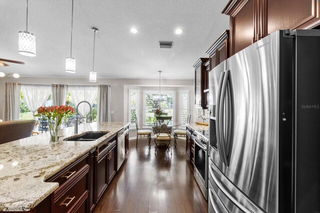 1142 Wolford Dr, Trinity, FL 34655 - kitchen featuring stainless steel appliances, a sink, plenty of natural light, dark wood-type flooring, and a textured ceiling