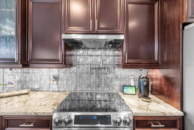 1142 Wolford Dr, Trinity, FL 34655 - kitchen with extractor fan, appliances with stainless steel finishes, tasteful backsplash, and light stone counters