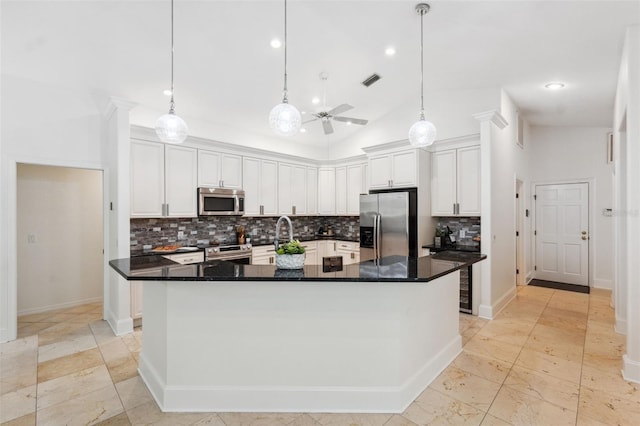 1471 N Jasmine Ave, Tarpon Springs, FL 34689 - kitchen with appliances with stainless steel finishes, backsplash, a spacious island, ceiling fan, and white cabinetry
