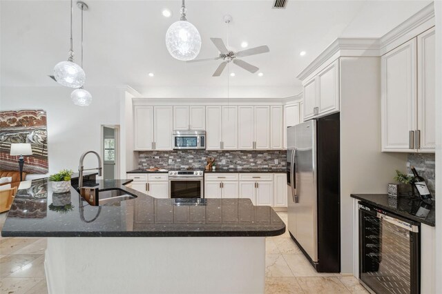 1471 N Jasmine Ave, Tarpon Springs, FL 34689 - kitchen with appliances with stainless steel finishes, a sink, wine cooler, tasteful backsplash, and a large island with sink