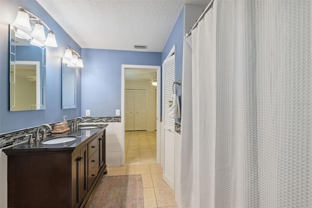 1471 N Jasmine Ave, Tarpon Springs, FL 34689 - full bathroom featuring double vanity, tile patterned floors, ceiling fan, a textured ceiling, and a shower with shower curtain