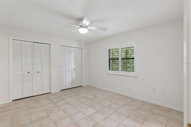 1471 N Jasmine Ave, Tarpon Springs, FL 34689 - unfurnished bedroom featuring two closets, baseboards, and ceiling fan
