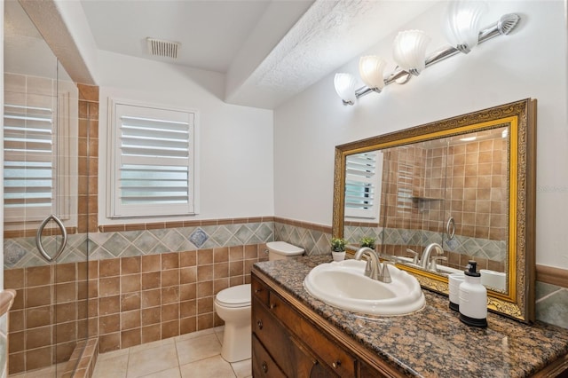 1471 N Jasmine Ave, Tarpon Springs, FL 34689 - full bath featuring toilet, vanity, tile patterned flooring, tile walls, and a wainscoted wall
