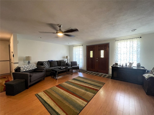 7534 Briarwood Dr, Port Richey, FL 34668 - living area featuring ceiling fan, a textured ceiling, and light wood finished floors