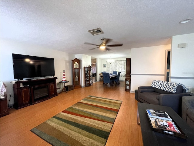 7534 Briarwood Dr, Port Richey, FL 34668 - living area with a ceiling fan, a textured ceiling, wood finished floors, and a fireplace