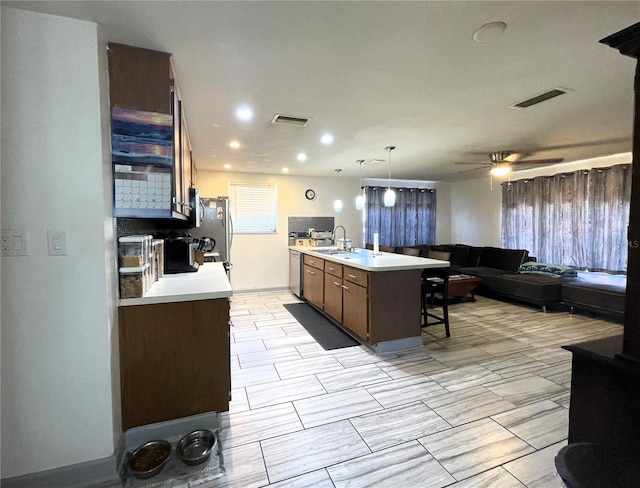 7534 Briarwood Dr, Port Richey, FL 34668 - kitchen with a breakfast bar area, open floor plan, light countertops, stainless steel appliances, and recessed lighting