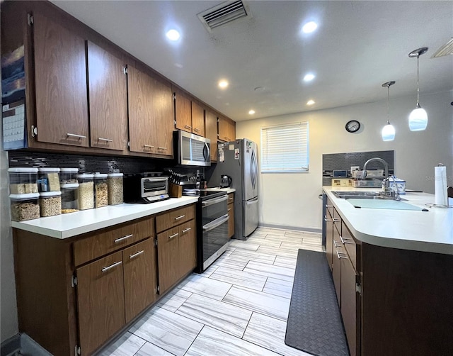 7534 Briarwood Dr, Port Richey, FL 34668 - kitchen with appliances with stainless steel finishes, light countertops, a sink, recessed lighting, and pendant lighting