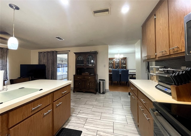 7534 Briarwood Dr, Port Richey, FL 34668 - kitchen featuring light countertops, tasteful backsplash, a sink, hanging light fixtures, and a chandelier