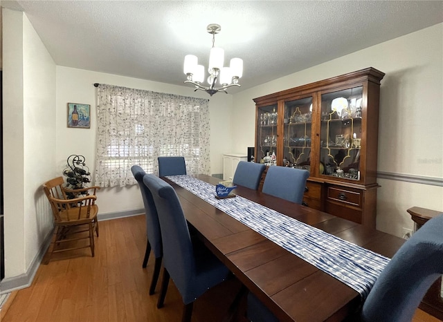7534 Briarwood Dr, Port Richey, FL 34668 - dining area featuring a chandelier, wood finished floors, and baseboards