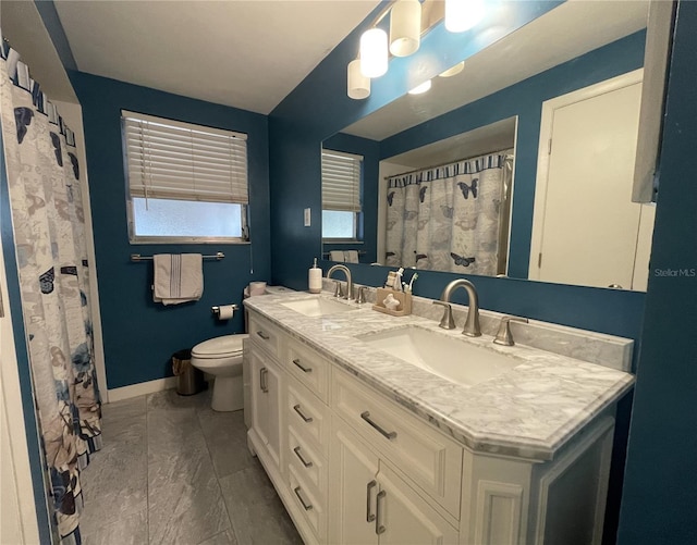 7534 Briarwood Dr, Port Richey, FL 34668 - full bathroom with double vanity, toilet, and baseboards