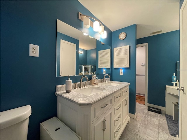 7534 Briarwood Dr, Port Richey, FL 34668 - bathroom with toilet, double vanity, marble finish floors, and baseboards