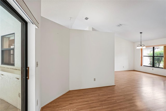 128 Oak Lake Dr, Spring Hill, FL 34608 - unfurnished room with a chandelier, light wood finished floors, and baseboards