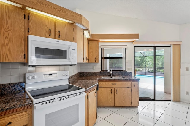 128 Oak Lake Dr, Spring Hill, FL 34608 - kitchen featuring white appliances, a sink, decorative backsplash, light tile patterned flooring, and dark stone countertops