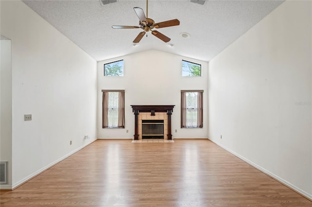 128 Oak Lake Dr, Spring Hill, FL 34608 - unfurnished living room featuring light wood-style floors, a ceiling fan, a fireplace, high vaulted ceiling, and a textured ceiling