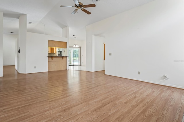 128 Oak Lake Dr, Spring Hill, FL 34608 - unfurnished living room featuring light wood-style floors, high vaulted ceiling, ceiling fan, and baseboards