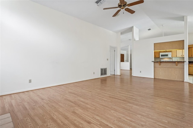 128 Oak Lake Dr, Spring Hill, FL 34608 - unfurnished living room with a ceiling fan, high vaulted ceiling, and light wood-style floors