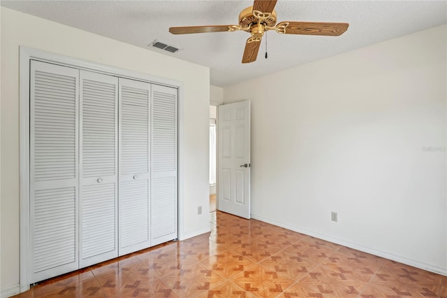 128 Oak Lake Dr, Spring Hill, FL 34608 - unfurnished bedroom with a closet, a textured ceiling, a ceiling fan, and baseboards