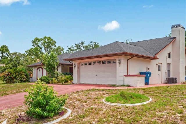 128 Oak Lake Dr, Spring Hill, FL 34608 - view of front facade featuring driveway, a garage, stucco siding, central AC, and a chimney