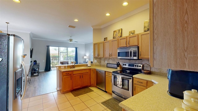 22316 Red Jacket Ln, Land O Lakes, FL 34639 - kitchen featuring appliances with stainless steel finishes, crown molding, a peninsula, light countertops, and a sink