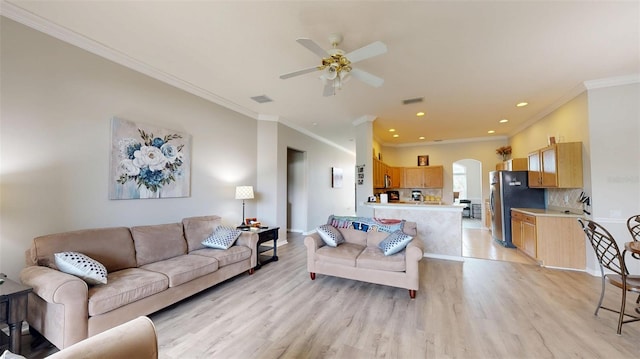 22316 Red Jacket Ln, Land O Lakes, FL 34639 - living room with arched walkways, crown molding, ceiling fan, light wood finished floors, and recessed lighting