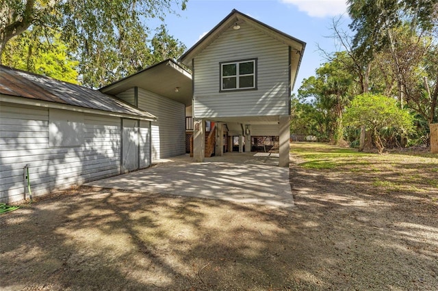 10844 W Yulee Dr, Homosassa, FL 34448 - back of house featuring a carport, stairs, driveway, and an outbuilding